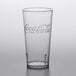 A clear plastic tumbler with a pebbled texture and a Coca-Cola logo.