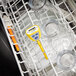 A yellow Comark waterproof digital pocket probe thermometer in a dishwasher.