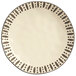 A white Libbey stoneware dinner plate with black dots.