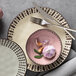 A Libbey pink stoneware soup bowl on a plate with a fork and knife.