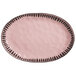 A pink oval stoneware platter with black trim.
