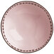 A close-up of a pink stoneware serving bowl with brown dots.