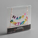A Creative Converting "Happy Birthday" cake topper banner in a clear plastic case.