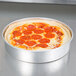 A pepperoni pizza in an American Metalcraft aluminum cake pan.
