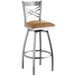 A Lancaster Table & Seating clear coat finish swivel bar stool with a light brown vinyl cushion.