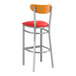 A Lancaster Table & Seating bar stool with a red vinyl seat and cherry wood back.