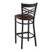 A Lancaster Table & Seating black cross back bar stool with a dark brown cushioned seat.