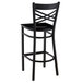 A Lancaster Table & Seating black metal cross back bar stool with a black wood seat.