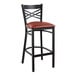 A Lancaster Table & Seating black cross back bar stool with a burgundy padded seat.