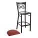 A black Lancaster Table & Seating cross back bar stool with a burgundy cushion.