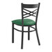 A Lancaster Table & Seating black metal chair with a green cushion.