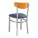 A Lancaster Table & Seating metal chair with a navy vinyl seat and cherry wood back.