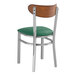A Lancaster Table & Seating metal chair with a green vinyl seat and wood back.
