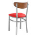 A Lancaster Table & Seating metal chair with red vinyl seat.