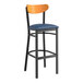 A Lancaster Table & Seating bar stool with a blue vinyl seat and cherry wood back.