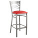 A Lancaster Table & Seating clear coat metal cross back bar stool with a red cushion.