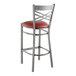 A Lancaster Table & Seating metal bar stool with a burgundy vinyl padded seat.