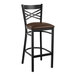 A Lancaster Table & Seating black cross back bar stool with a dark brown vinyl padded seat.