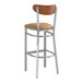 A Lancaster Table & Seating bar stool with a light brown vinyl seat and a wooden back.