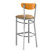 A Lancaster Table & Seating bar stool with a light brown vinyl seat and cherry wood back.