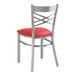 A Lancaster Table & Seating clear coat finish cross back chair with a red vinyl padded seat.