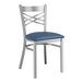 A Lancaster Table & Seating metal cross back chair with a navy blue cushion.