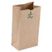A person holding a Duro heavy duty brown paper bag with green text.