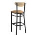 A Lancaster Table & Seating black bar stool with a light brown vinyl seat and driftwood back.