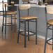 Lancaster Table & Seating bar stools with a wood back and seat.