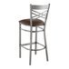 A Lancaster Table & Seating metal cross back bar stool with a dark brown seat.
