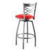 A Lancaster Table & Seating clear coated metal bar stool with a red vinyl cushion.