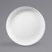 A white Elite Global Solutions round melamine coupe plate with a white rim.