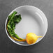 A white Elite Global Solutions melamine bowl with a radish and leaf in it.