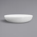 A close up of a white Elite Global Solutions melamine bowl on a gray surface.