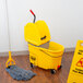 A yellow Rubbermaid WaveBrake mop bucket with a gray dirty water bucket inside.