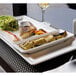 A RAK Porcelain ivory rectangular platter with fish and vegetables on it.
