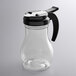 A clear polycarbonate teardrop syrup server with a black top.