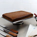 A Devil's Food cake on a metal tray with knives.