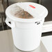 A Rubbermaid white ingredient storage bin with a clear sliding lid on a counter.