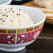A bowl of rice with black sesame seeds in a Thunder Group Longevity melamine bowl.