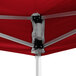 A close up of a red Backyard Pro Courtyard Series instant canopy with metal poles.