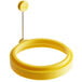 A yellow silicone egg ring with a metal handle.