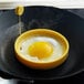 A fried egg in a Lodge yellow non-stick silicone egg ring.