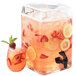 A Cal-Mil square glass beverage dispenser filled with pink lemonade with strawberry and orange slices in it.