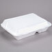 A white Genpak foam container with hinged lid.