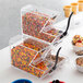 A stackable plastic container with candy and different colored sprinkles.