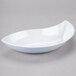A white bowl with a curved edge on a gray background.