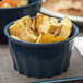 A close up of food in a dark blue Dinex convection bowl.
