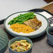 A Dinex underliner with a plate of chicken, rice, and green beans on a tray.