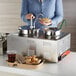 A woman using an Avantco countertop food warmer to serve herself.